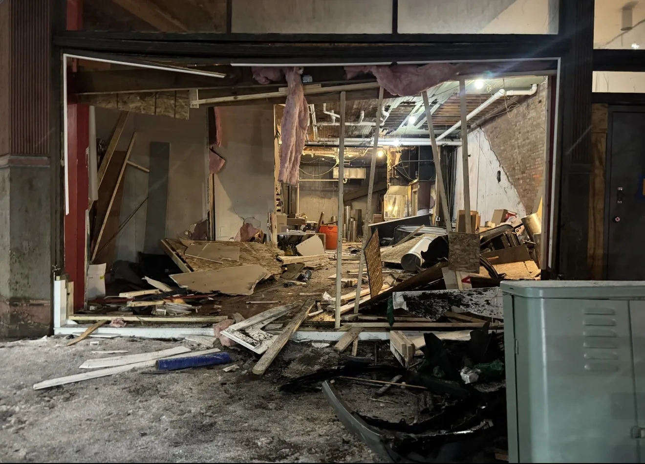 Collapsed interior wall and debris after storefront structural failure