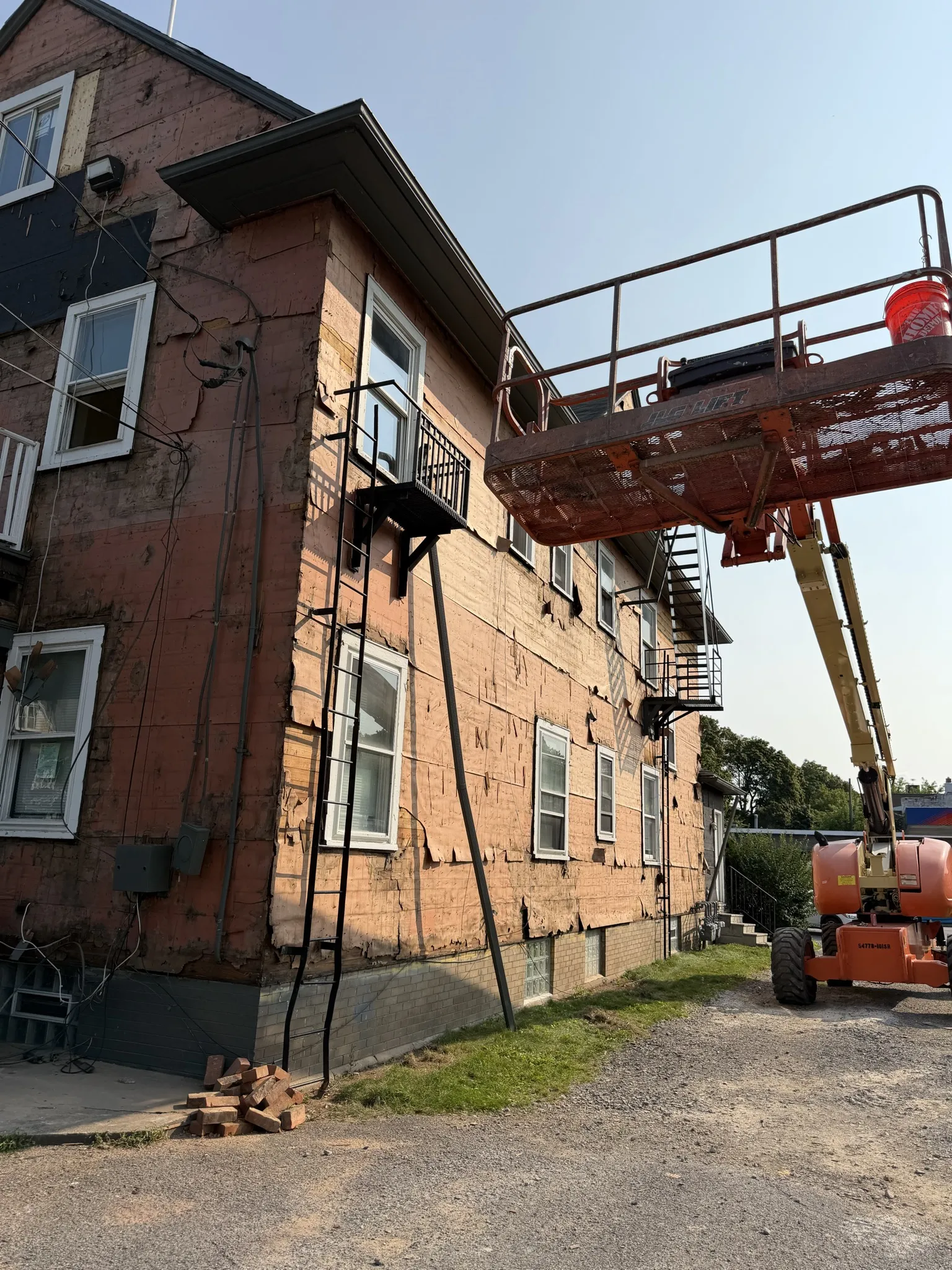 Boom lift used for siding removal on multi-story building