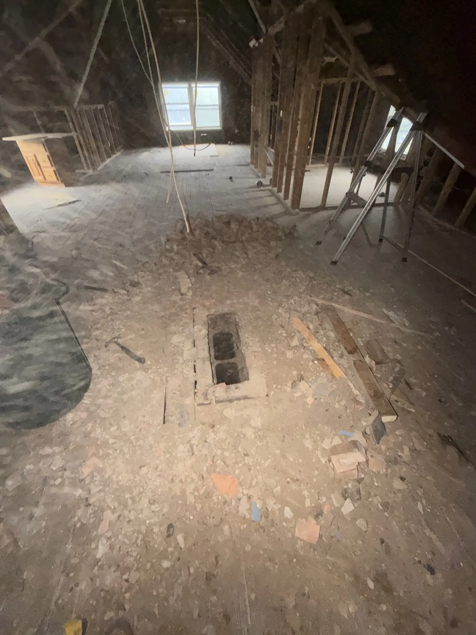Attic floor debris and exposed framing during demo phase